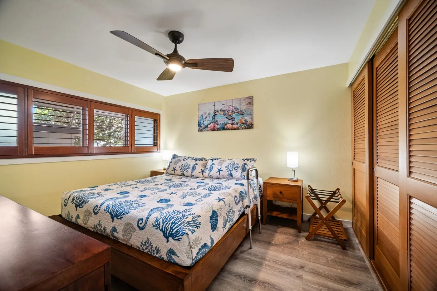 Bedroom with lower-height bed, shutters, and closet