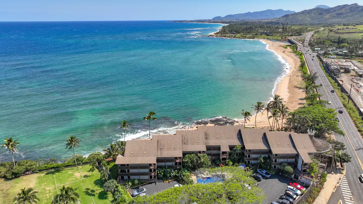 Aerial of Wailua Bay View — the oceanfront building, beach, and turquoise coast