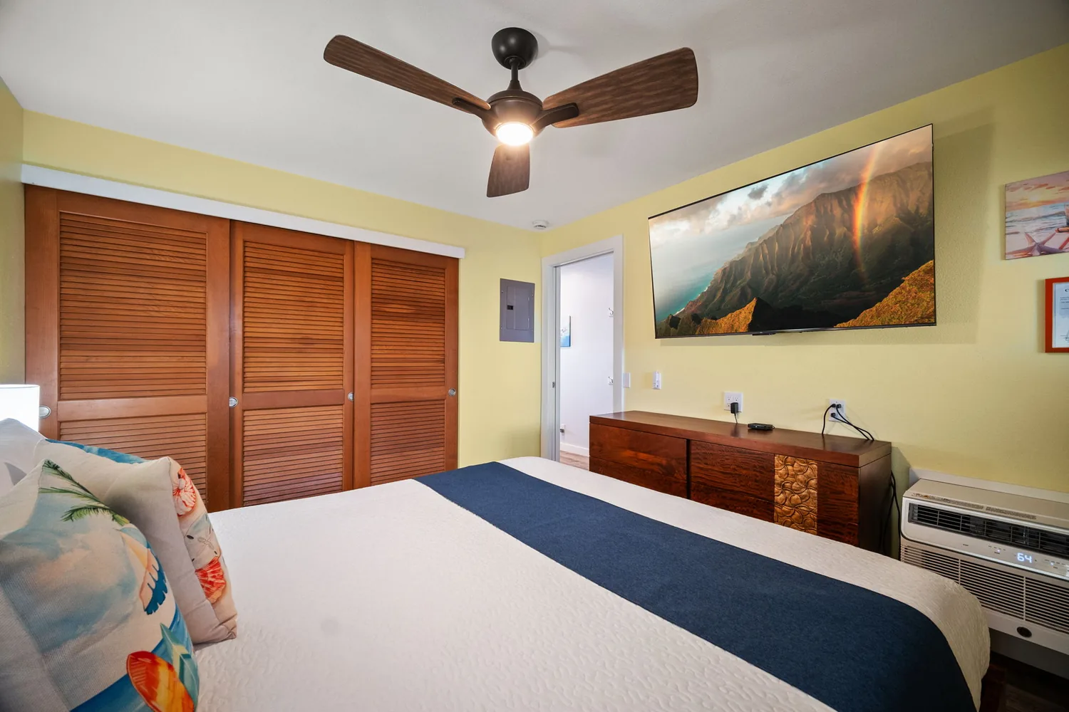 Bedroom with closet, dresser, and wall-mounted TV