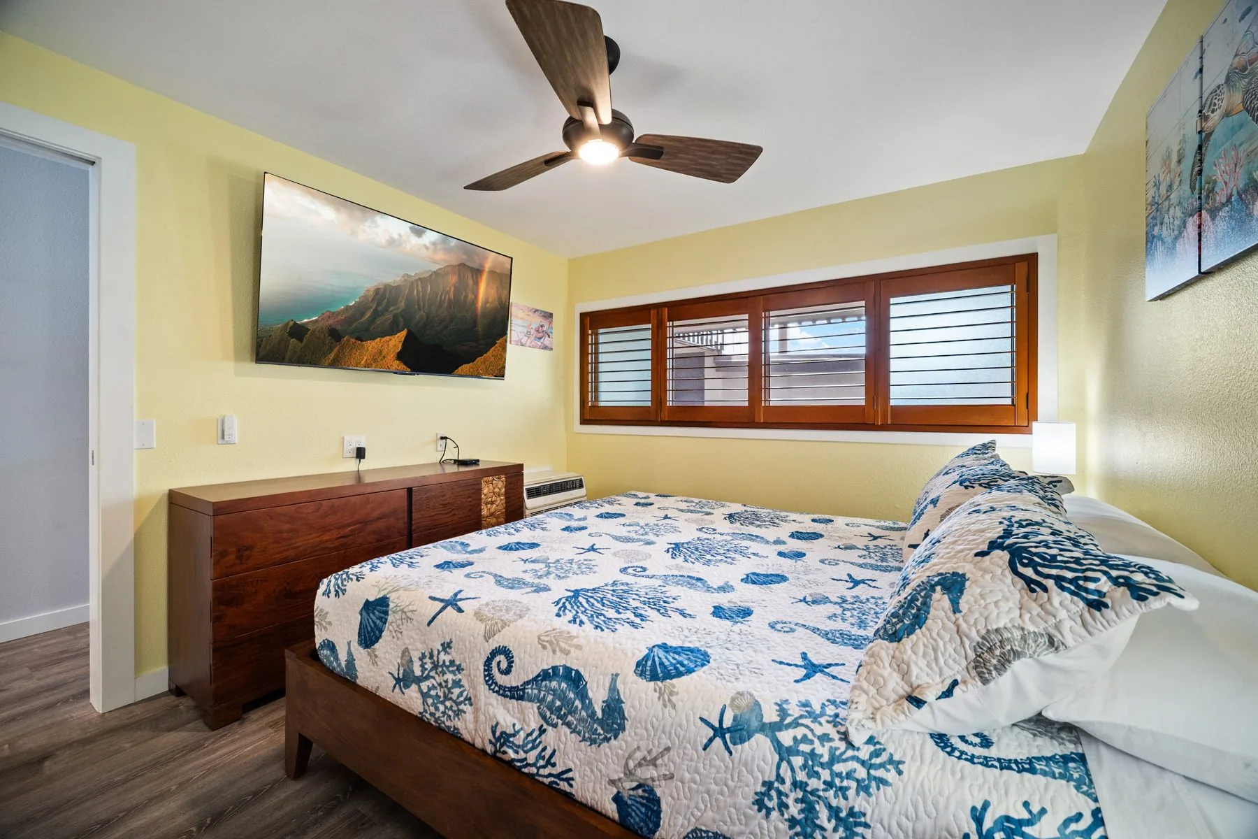 Bedroom with California King bed, dresser, and TV — in-wall HDMI 3-port plate below the TV for plugging in your own streaming device or laptop
