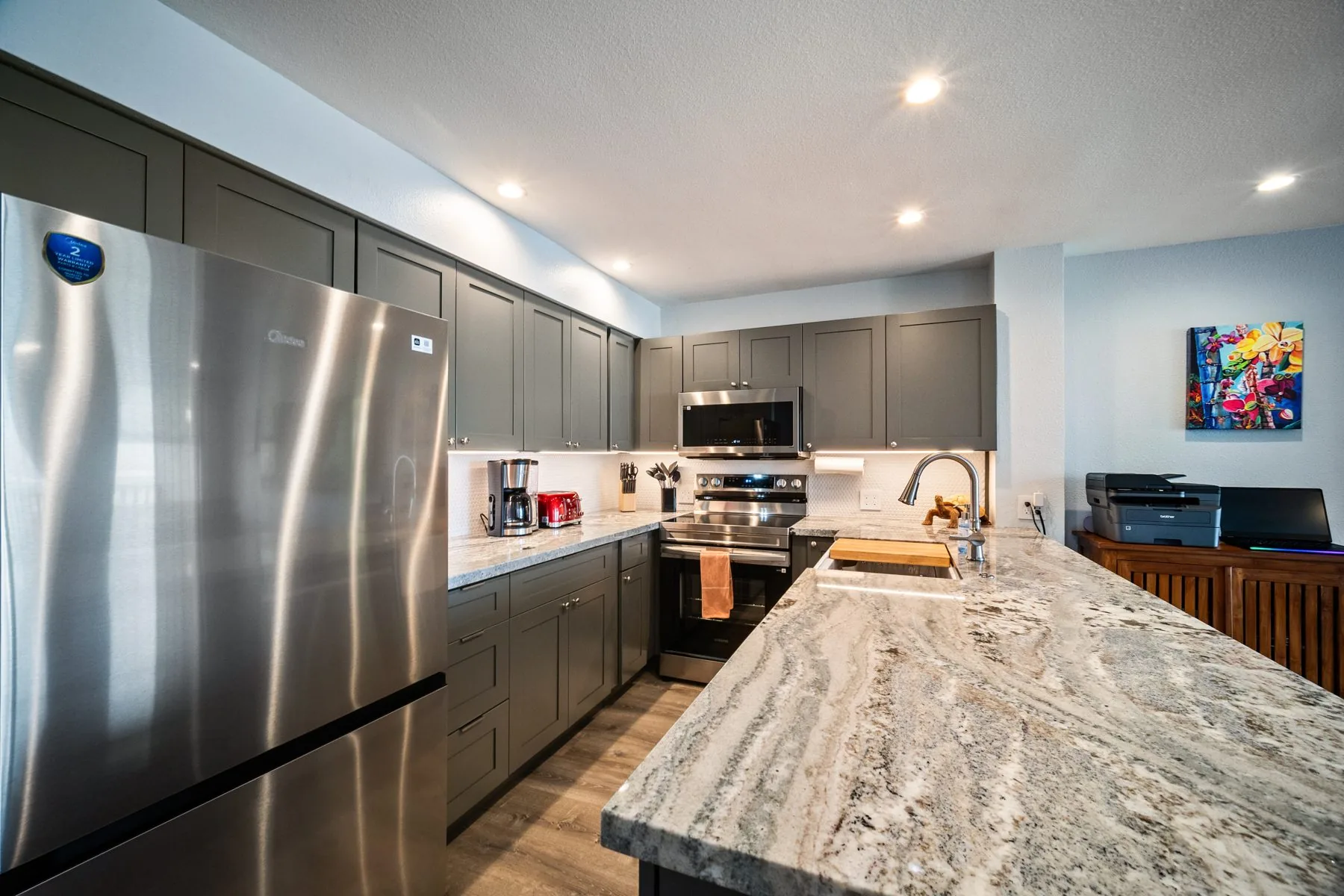 Renovated kitchen with stainless range, refrigerator, and coffee station