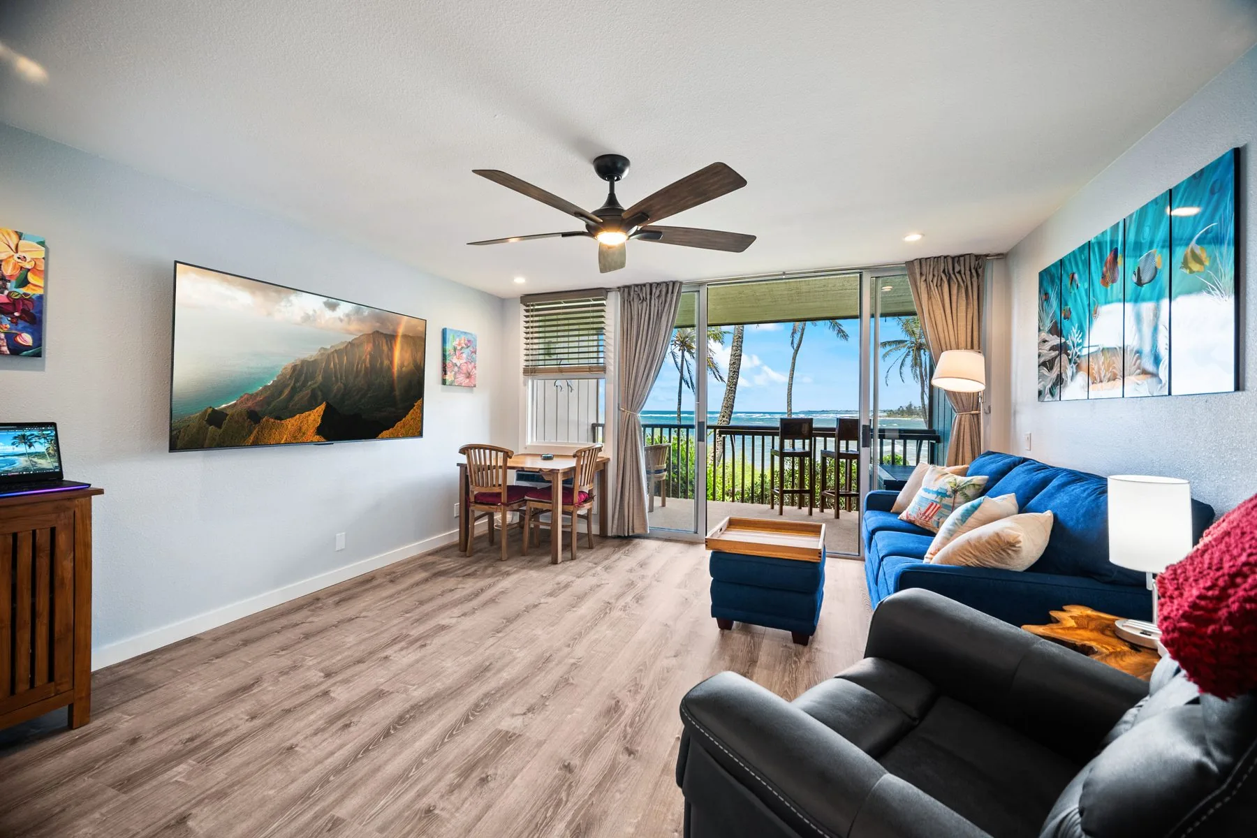 Living room with large-screen TV, sofa, and ocean view