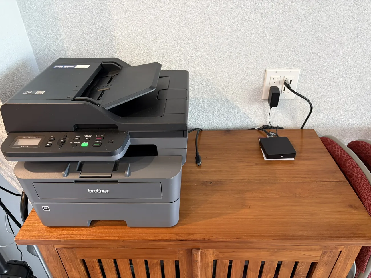 The unit's tech station — Brother all-in-one printer beside the in-wall HDMI plate and streaming box